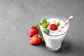 Glass of milkshake with strawberries and mint on a concrete surface. Kefir cocktail with strawberries and banana. close-up. Royalty Free Stock Photo