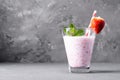 Glass of milkshake with strawberries and mint on a concrete surface. Kefir cocktail with strawberries and banana. close-up. Royalty Free Stock Photo