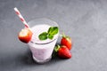 Glass of milkshake with strawberries and mint on a concrete surface. Kefir cocktail with strawberries and banana. close-up. Royalty Free Stock Photo