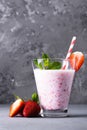 Glass of milkshake with strawberries and mint on a concrete surface. Kefir cocktail with strawberries and banana. close-up. Royalty Free Stock Photo