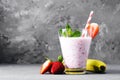 Glass of milkshake with strawberries and mint on a concrete surface. Kefir cocktail with strawberries and banana. close-up. Royalty Free Stock Photo