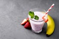 Glass of milkshake with strawberries and mint on a concrete surface. Kefir cocktail with strawberries and banana. close-up. Royalty Free Stock Photo