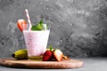 Glass of milkshake with strawberries and mint on a concrete surface. Kefir cocktail with strawberries and banana. close-up. Royalty Free Stock Photo