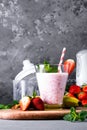 Glass of milkshake with strawberries and mint on a concrete surface. Kefir cocktail with strawberries and banana. close-up. Royalty Free Stock Photo