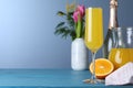 Glass of Mimosa cocktail on light blue wooden table. Space for text