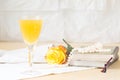 Glass of mimosa cocktail with vintage books and pearls