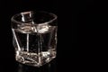 Glass with mineral water with bubbles on black background Royalty Free Stock Photo