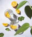 A glass of mineral water and a slice of orange on a gray table with fresh juicy fruit oranges with hard shadows. Summer time. Top Royalty Free Stock Photo