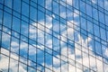 Glass mirror skyscraper wall with blue sky and white clouds reflection close up, modern business center view Royalty Free Stock Photo