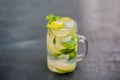 Glass of mojito with lime and mint ice cube close-up on dark wood background Royalty Free Stock Photo