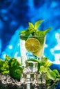 Glass of mojito with lime and mint ice cube close-up red straw on blue background Royalty Free Stock Photo