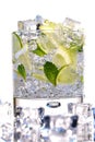 Glass of Mojito summer alcoholic cocktail with ice cubes mint and lime on white background with raw lime and mint leaf Royalty Free Stock Photo