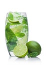 Glass of Mojito summer alcoholic cocktail with ice cubes mint and lime on white with raw lime and mint leaf Royalty Free Stock Photo