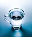 Glass mug with boiling water. Unusual color processing and high contrast. Turquoise hue.