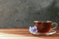 A glass mug with a chicory drink. A blue chicory flower floats in a cup with a drink