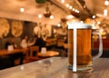 Glass mug with cold tasty beer on wooden table in pub, space for text Royalty Free Stock Photo