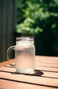 A glass mug filled with ice water on a hot day