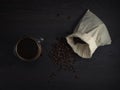 Glass mug with fresh black natural coffee, a bag with coffee grains and sprinkled grains of roasted coffee on a wooden table Royalty Free Stock Photo