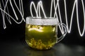 Glass mug with green tea on a dark background. Translucent glass and tea cup. Tea photo