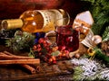 Glass mug of grog lying next to red wine bottle .