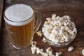 Glass mug of light beer with popcorn on wooden table, close up Royalty Free Stock Photo