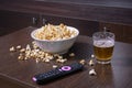 Glass mug of light beer with popcorn on wooden table, close up Royalty Free Stock Photo