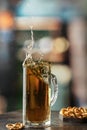 Glass mug of light cold beer with splash and flying drops with snacks on the table in pub Royalty Free Stock Photo