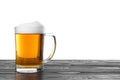 Glass mug of tasty beer on black wooden table against white background Royalty Free Stock Photo