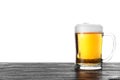 Glass mug with tasty beer on black wooden table against white background Royalty Free Stock Photo