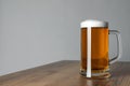 Glass mug of tasty dark beer on wooden table against grey background. Space for text Royalty Free Stock Photo