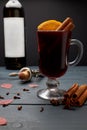 Glass of mulled wine, bottle of red wine and corkscrew with open cork on wooden table. Royalty Free Stock Photo