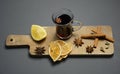 A glass of mulled wine on a wooden board with cinnamon sticks and lemon. Top view. Grey background Royalty Free Stock Photo