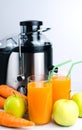 A glass of multivitamin juice, apples, carrots and a juicer on the table. Natural and healthy juices. Vertical photo. Close-up