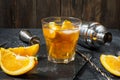 A glass of Negroni cocktail with orange and lemon. Alcoholic drink with rum and vermouth on dark stone table Royalty Free Stock Photo