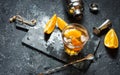 A glass of Negroni cocktail with orange and lemon. Alcoholic drink with rum and vermouth on dark stone table. With space for text Royalty Free Stock Photo