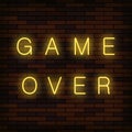 Glass Neon Game Over Sign on Solid Red Brick Wall Background. Gaming Concept. Video Game Screen. Royalty Free Stock Photo