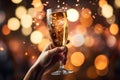 A glass of New Year\'s champagne in a hand with a blurred background