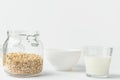 Glass of non-diary animal-free plant based milk rolled oats in reusable crystal jar bowl on white kitchen table. Healthy breakfast Royalty Free Stock Photo