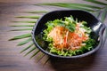 Glass noodles with salad in a bowl on wooden table background. Asian cooked rice noodles with fresh carrot Royalty Free Stock Photo