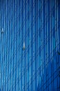 Glass office building in a city. Two windows open to let fresh air in. Business office glass building reflects blue sky. Royalty Free Stock Photo