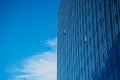 Glass office building in a city. Two windows open to let fresh air in. Business office glass building reflects blue sky. Royalty Free Stock Photo