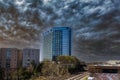 Glass office buildings and apartments along a side a set of railroad tracks with powerful blue storm clouds in the sky Royalty Free Stock Photo