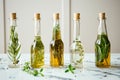 glass oil and vinegar bottles with herbs inside on marble Royalty Free Stock Photo