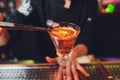 Glass of orange cocktail decorated with lemon at bar counter background. Royalty Free Stock Photo