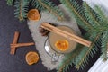 A glass of orange drink stands on a piece of linen. A slice of dried orange floats in it. Nearby are cinnamon sticks and dried Royalty Free Stock Photo