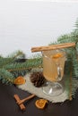 A glass of orange drink stands on a piece of linen. A slice of dried orange floats in it. Nearby are cinnamon sticks and dried Royalty Free Stock Photo