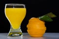 Glass with orange juice, a cut orange