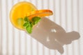 Glass of orange juice with mint leaves and slice of orange in bright sunshine Royalty Free Stock Photo