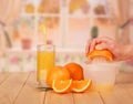 A glass orange juice, orange slices, woman`s hand holding half o Royalty Free Stock Photo