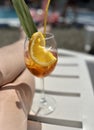 A glass of orange juice and a piece of lemon on the beach Royalty Free Stock Photo